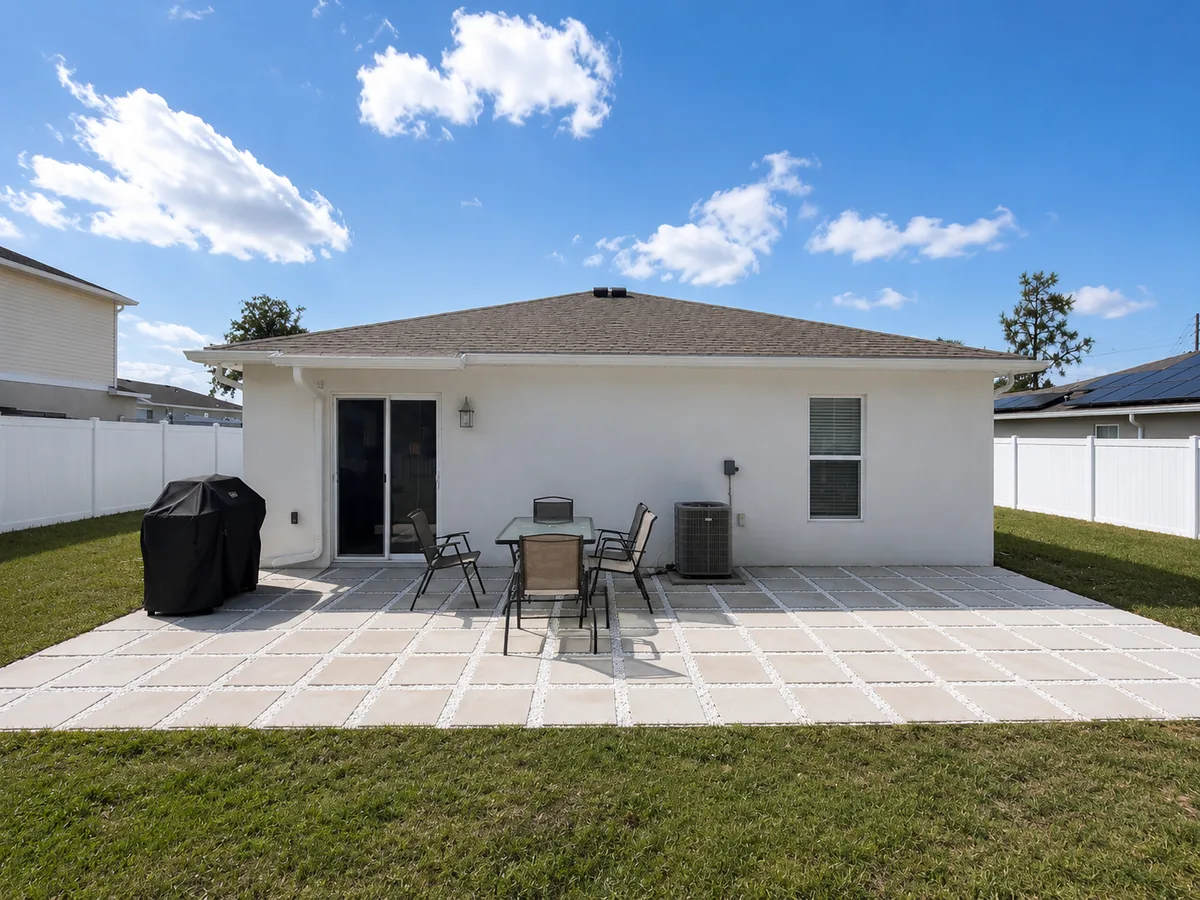 Back patio with a grill and outdoor dining table