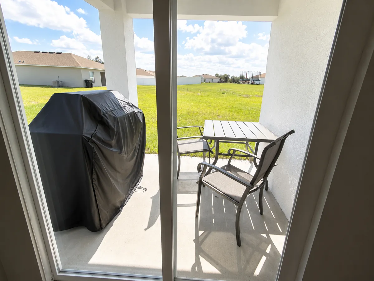 Covered back patio with a grill, looking out over the yard
